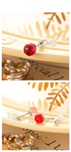 Macro detail of 6mm faceted crystal ball stud earrings with red and pink teardrop beads