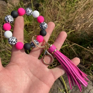 Close-up of silicone bead keychain wristlet with leopard print and pink PU tassel charm