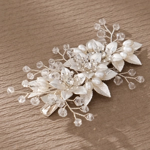 Detailed view of silver bridal hair clip with handmade pearls and crystal floral motifs