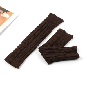 Close-up of dark brown cable knit leg warmers showing detailed texture and patterns