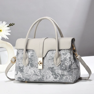 Vue détaillée d'un sac à main gris avec broderie argentée et fermoir en métal doré