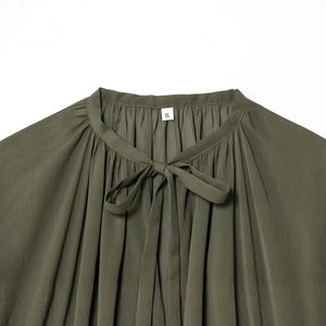 Army green long sleeve blouse featuring a pleated fabric texture and tie-neck bow design