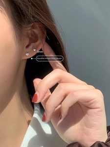 Detail view of mini 3mm heart-shaped S925 sterling silver stud earring worn on ear