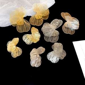 Détail macro de grandes boucles d'oreilles fleurs ajourées or et argent avec texture de fils