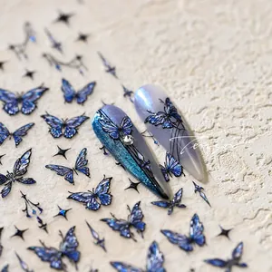 Macro shot of blue butterfly nail stickers with shiny gold foil and glitter details