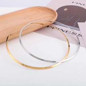 Minimalist flat metal choker set in gold and silver finish on a wooden tray
