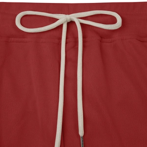 Detail of red heavy cotton sweatpants waistband featuring adjustable cream drawstrings