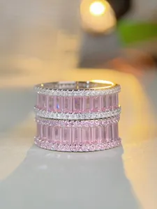 Macro detail of stacked S925 silver rings with pink emerald cut stones and micro pavé