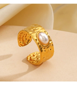 Close-up of golden hammered geometric ring with a white oval pearl inlay