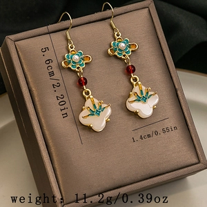 Detailed view of Chinese style tassel earrings with jade-like beads and white flower charm