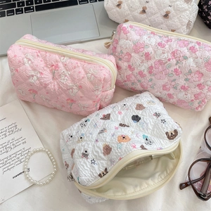 Quilted cosmetic bags with floral, bunny, and bear patterns in a flat lay desktop view