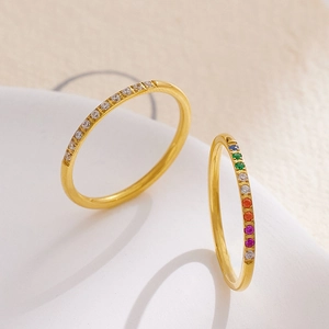 Detail of minimalist gold-plated rings with rainbow gemstones and white zircon crystals