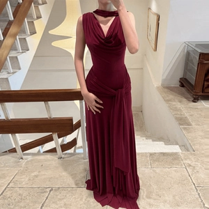 Detail of burgundy backless halter dress with elegant waist pleats and draped tie ribbons