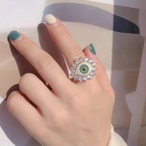 Detail of bohemian evil eye ring with green resin eye and sparkling zircon pavé