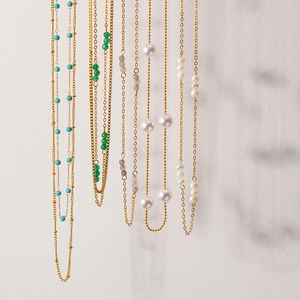 Detailed macro view of 18K gold plated necklaces with pearls and colorful turquoise beads