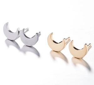 Detail of crescent moon stud earrings in polished gold and silver finishes