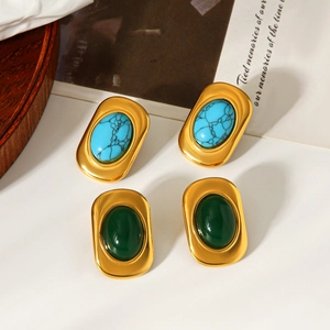 Détail de boucles d'oreilles vintage en or 18k avec turquoise et pierre aventurine
