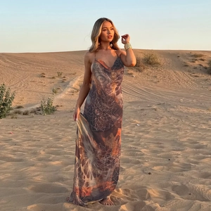 Détail de la robe longue dos nu à fleurs dans un décor de désert au coucher du soleil