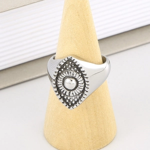 Detailed view of silver sunflower evil eye shield ring on a wooden cone display stand