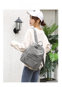 Fashionable grey nylon backpack for women shown from behind on model for size and style