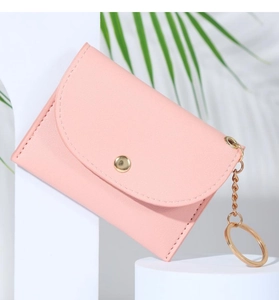 Close-up of pink PU leather coin purse with golden button and keychain ring