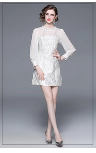 Detail of white embroidery short dress with lace collar and long sleeves