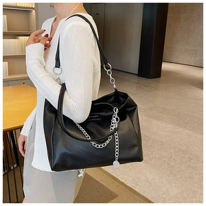Close-up of large black tote bag with lychee leather texture and silver chain detail