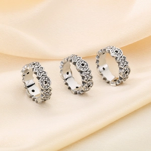 Detailed view of three vintage silver rings with cross relief and cubic zirconia on silk