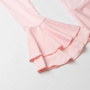 Detailed close-up of pink layered ruffle cuffs and flare sleeves on knitted dress
