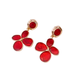 Vintage red enamel flower earrings with gold trim and sterling silver pins on white background