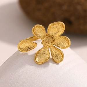 Vintage 18K gold-plated flower ring with hammered texture and pearl center on rock