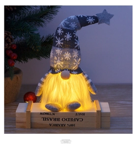 Close-up of glowing Christmas gnome with warm LED light and snowflake knit hat decor