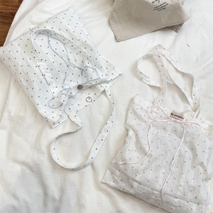 Detail shot of heart pattern canvas tote bags with delicate ribbon bow ties