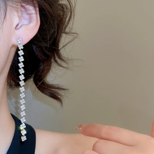 Close-up of model wearing silver tassel earrings with square cubic zirconia drops