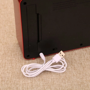 Detail of Christmas TV music box back showing battery compartment and USB power cable