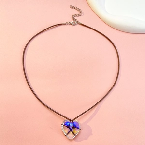 Détail d'un pendentif coeur irisé transparent avec corde tressée marron et fermoir homard
