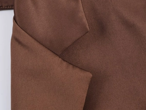 Gros plan du revers d'un blazer en satin marron café avec une texture brillante