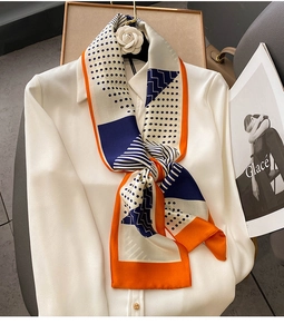 Detail of silk-like neckerchief with orange borders and blue polka dots on white shirt
