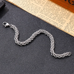 Detail of stainless steel lantern chain bracelet with lobster clasp on vintage newspaper