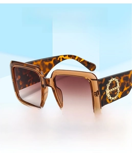 Detail of square tortoiseshell sunglasses with gold bamboo joint metal accent on the temple