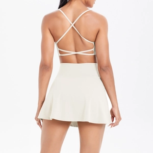 Detail von Cross-Back Yoga-Top und Falten-Tennisrock aus cremeweißem Funktionsstoff