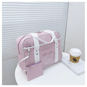 Detailed view of pink JK uniform bag with heart-shaped window and small coin purse