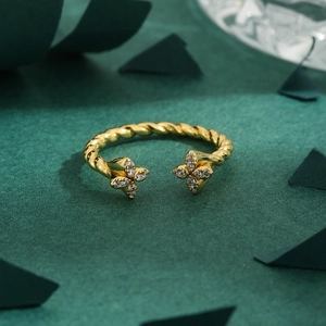 Golden twisted rope ring with clover shaped ends set with sparkling cubic zirconia stones