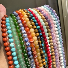 Detailed close-up of 3mm faceted natural stone beads in various vibrant colors held in hand