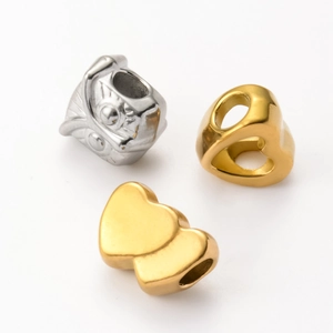 Detailed macro of golden heart charms and silver lion head beads for DIY jewelry making