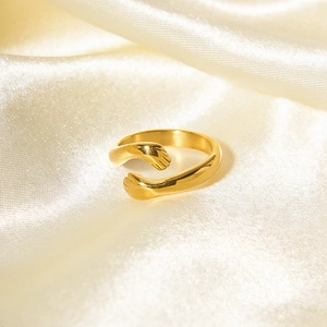 Polished 18k gold plated stainless steel hugging hands open ring on white silk fabric