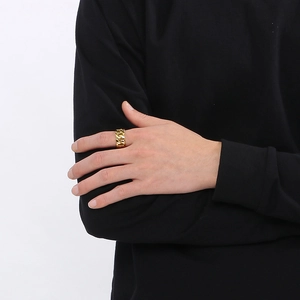 Close-up of a gold Cuban link style stainless steel ring worn on a model hand