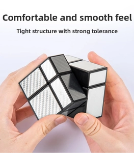 Detailed shot of hands rotating a 2x2 silver mirror cube with carbon fiber texture