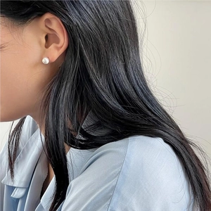 Minimalist 925 sterling silver round pearl stud earrings worn by a model for a clean look
