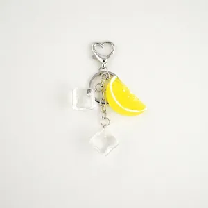 Detail of realistic lemon slice keychain with transparent ice cube charms and heart clasp